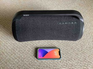 Picture of an iPhone in front of the Sony XG500 boombox speaker.