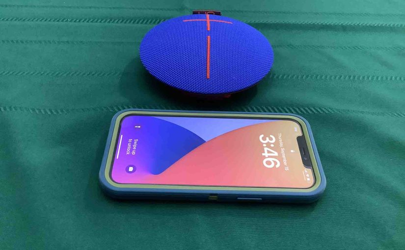 Picture of an iPhone in front of the UE Roll 1 speaker.