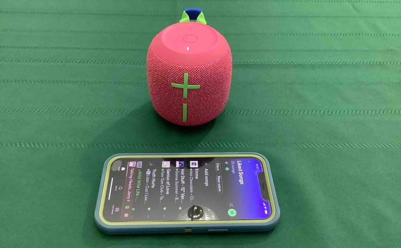Picture of an iPhone sitting in front of a UE Wonderboom 3 BT speaker.
