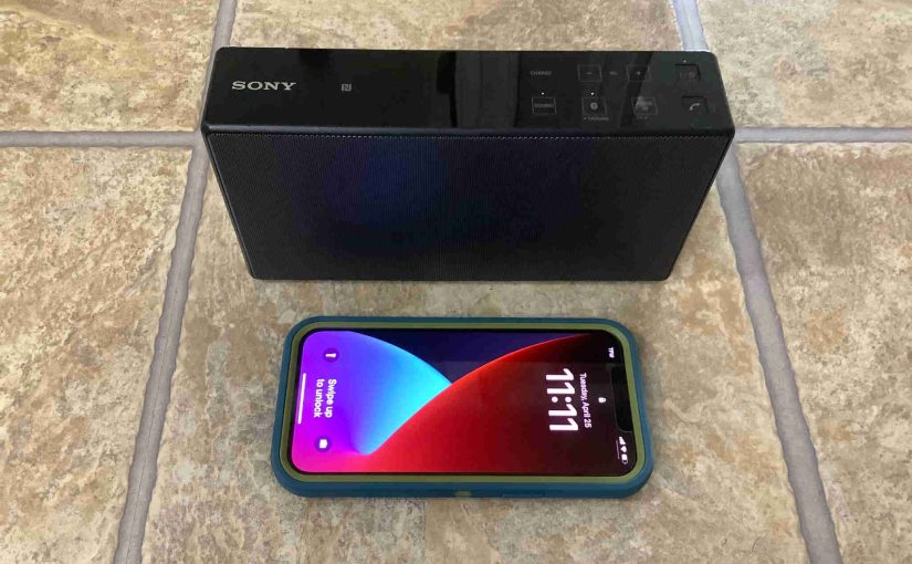 Picture of the Sony SRS X5 beside the iPhone 12 Pro Max.